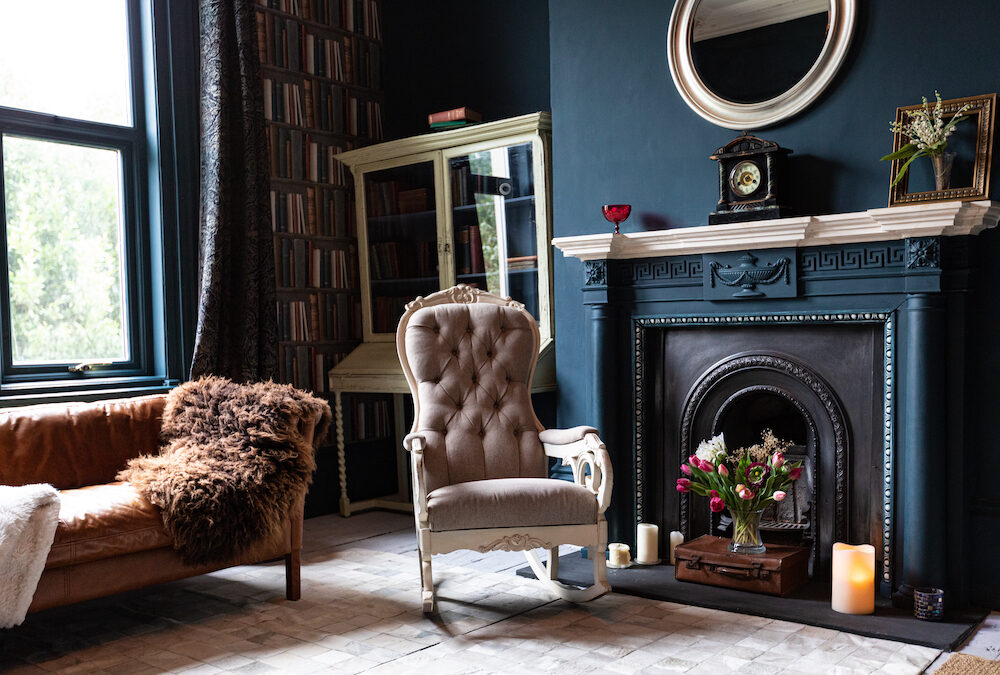 Traditional Living Room Design in blue tones with a bookshelf, fireplace and antique furniture