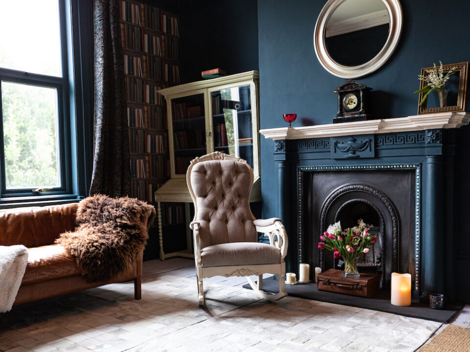 Traditional Living Room Design in blue tones with a bookshelf, fireplace and antique furniture