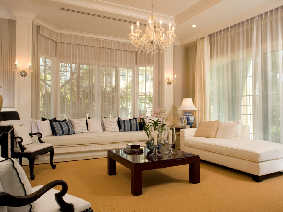 Traditional Design Living Room with white sofas, chairs with wood accents and white drapery