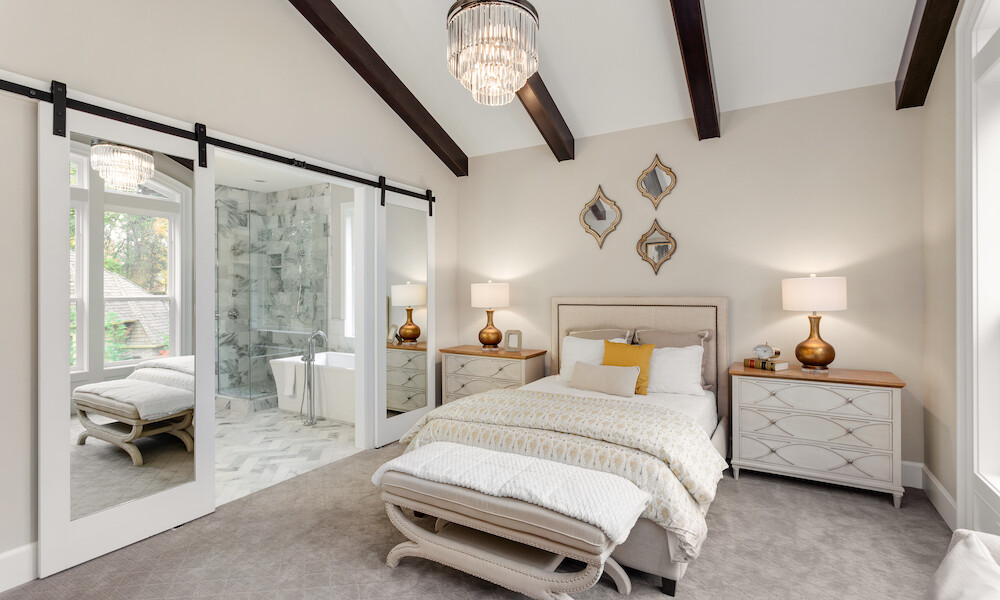 Contemporary Design Bedroom in beige and brass with a barn door with mirrors for the bathroom