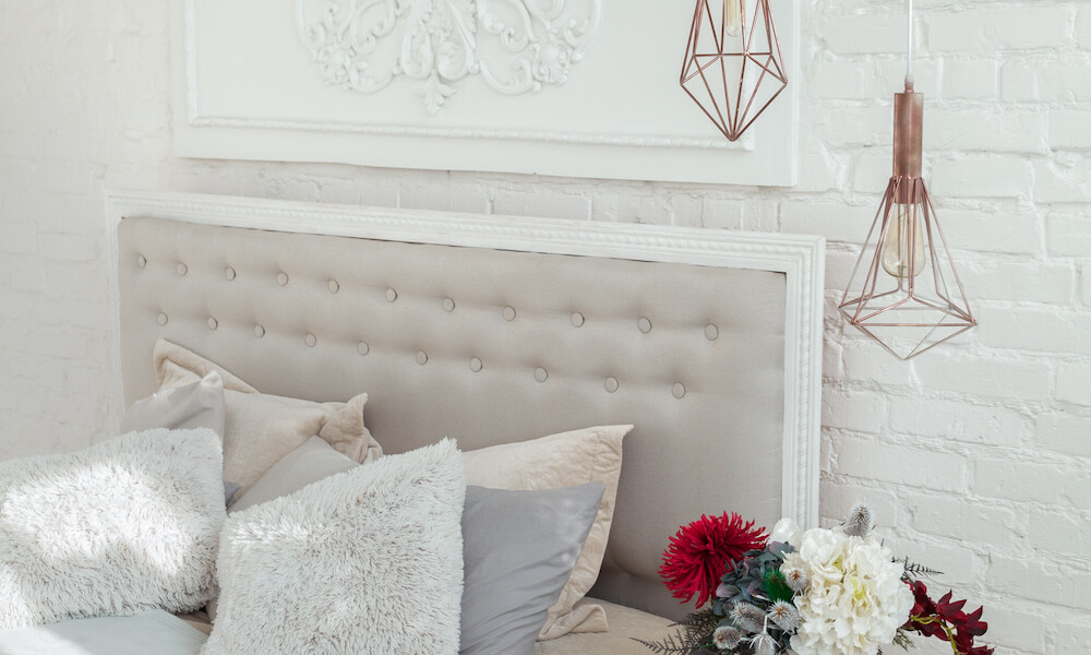 Eclectic Design Style Bedroom with light grey bed frame and throw pillows and hanging lighting