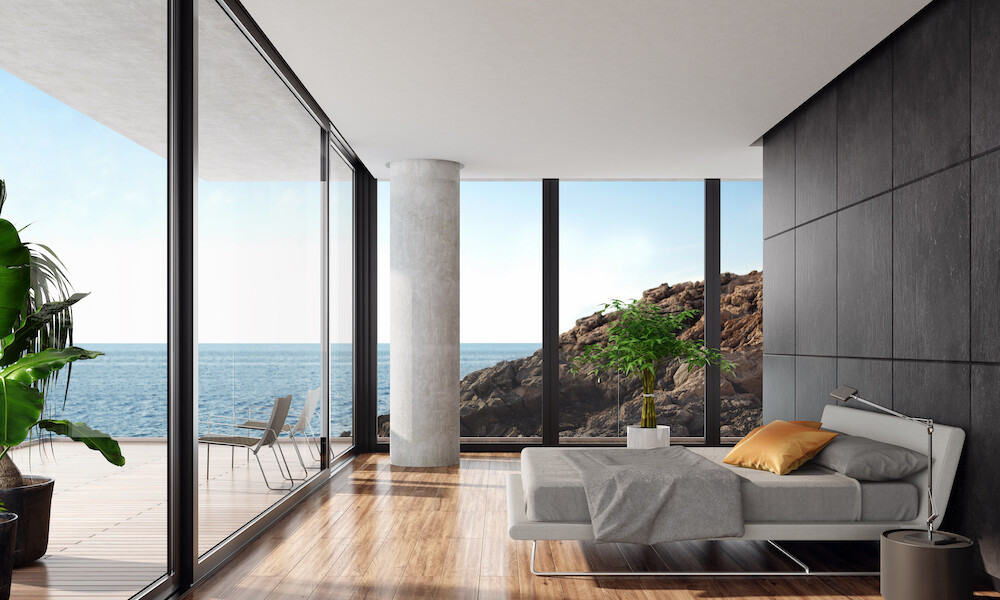 Modern Bedroom Design with a low minimalist grey bed with floor to ceiling grey natural stone large titles