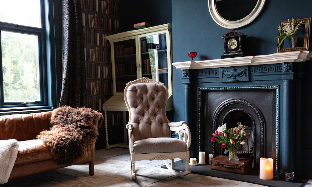 Traditional Living Room Design in blue tones with a bookshelf, fireplace and antique furniture